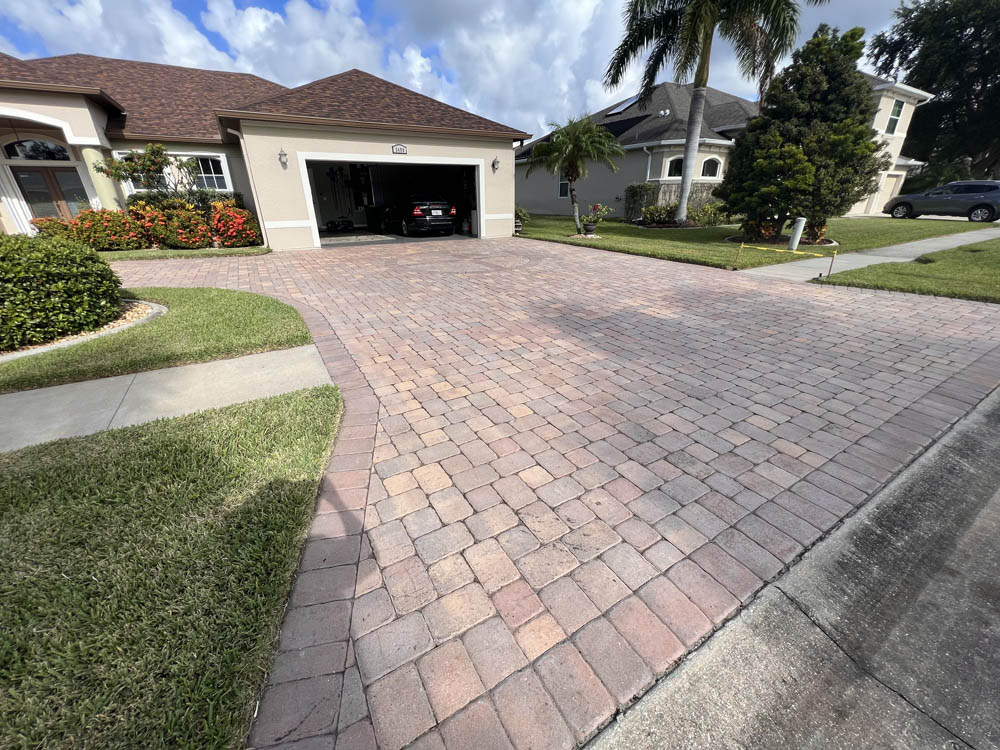 Worn and dirty paver driveway before paver sealer and pressure washing services from Stellar Clean and Seal in Brevard County